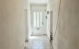 Světlá vstupní chodba s dlažbou a bílými dveřmi.